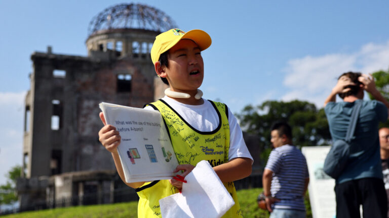 Young student makes Hiroshima bombing more personal for visitors at Peace Park.